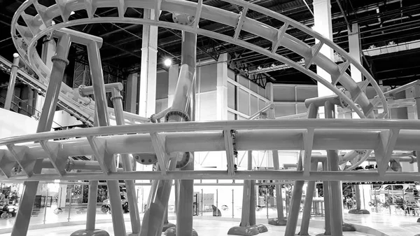 Black and white image of extreme roller coaster with loops in amusement park — Stock Photo, Image