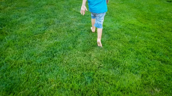 Closeup imagem de 3 anos de idade criança descalça menino correndo em hte grama verde fresco no parque — Fotografia de Stock