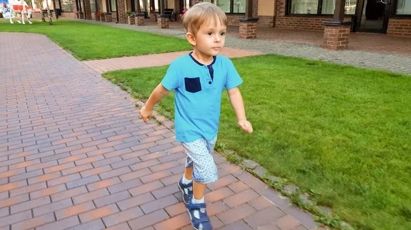 Adorable niño de 3 años corriendo en la pequeña calle de la ciudad europea — Foto de Stock