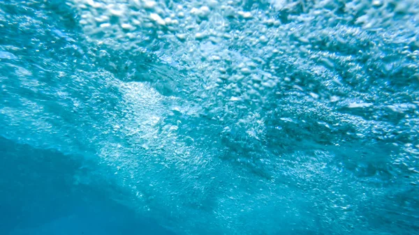 Zbliżenie obrazu pęcherzyków powietrza w wodzie morskiej. Strzał z wnętrza toczenia rury fali oceanu — Zdjęcie stockowe