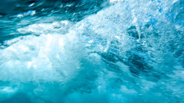 Photo abstraite rapprochée de grosses vagues ondulantes et tourbillonnantes. Bulles d'air coulant dans l'eau de l'océan — Photo