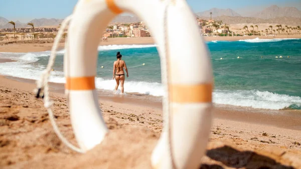 Όμορφη εικόνα από λευκό πλαστικό δαχτυλίδι εξοικονόμησης ζωής στέκεται στην αμμώδη παραλία της παραλίας σε φωτεινή ηλιόλουστη μέρα. Τέλεια βολή για να απεικονίσει καλοκαιρινές διακοπές διακοπών στον ωκεανό. — Φωτογραφία Αρχείου