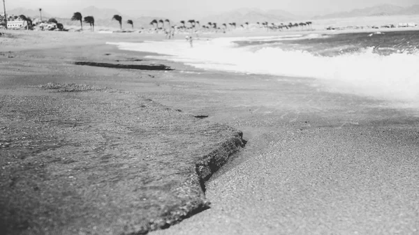Güzel kumlu deniz plajı ve okyanus dalgaları kıyıda kırma siyah beyaz görüntü — Stok fotoğraf