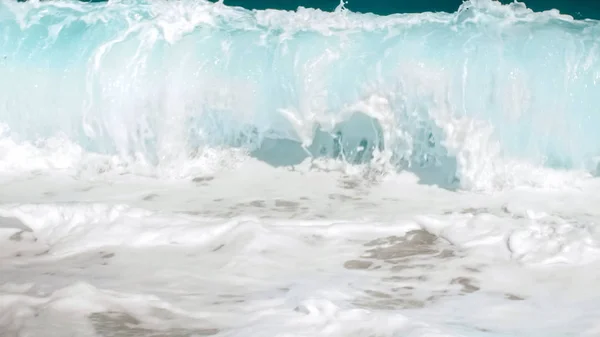 Sahil boyunca yuvarlanan deniz dalgalarının yakın çekim görüntüsü. Okyanus gelgitleri kıyıyı eziyor — Stok fotoğraf