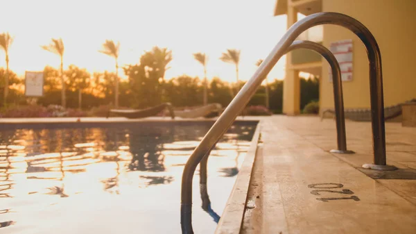 Nahaufnahme getönte Bild von Metall-Staricase beim Schwimmen in luzurious Villa gegen schönen Sonnenuntergang Himmel — Stockfoto