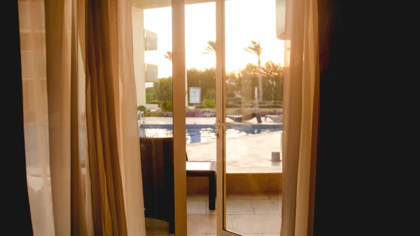 Foto da grandi finestre aperte su lussuosa villa al tramonto cielo e piscina all'aperto — Foto Stock