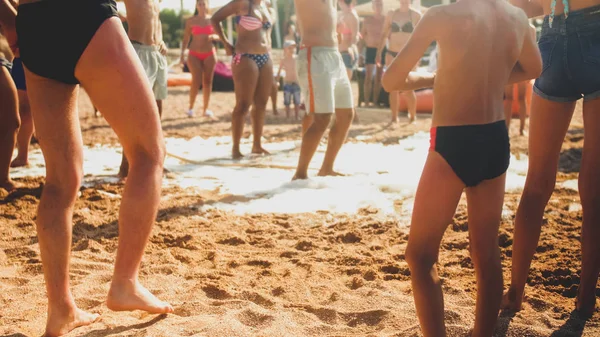 Imagen borrosa de la gran multitud bailando en la playa del mar en las vacaciones de verano. Personas divirtiéndose y celebrando . —  Fotos de Stock