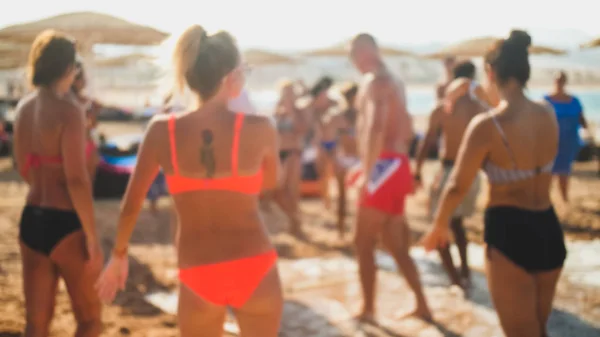 Foto borrosa de jóvenes amigos bailando en la fiesta disco de jabón en la playa del mar —  Fotos de Stock