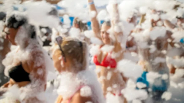 Defocused image of big group of people dancing on the sea beach disco party. People having fun during summer holiday vacation — Stock Photo, Image