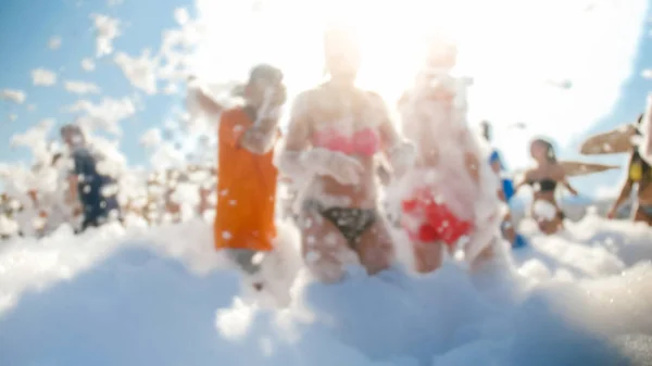 Blurred image of big crowd dancing on the sea beach on summer holiday vacation. People having fun and celebrating. — Stock Photo, Image