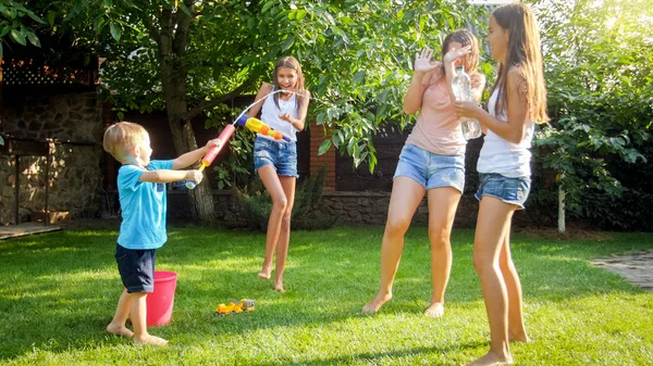 Entzückender 3-jähriger Kleinkind Junge spritzt Wasser aus Plastikspielzeugpistole im Hinterhof des Hauses. Kinder spielen und spielen im Sommer im Freien — Stockfoto