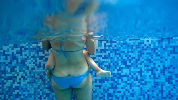 Yüzme havuzunda dinlenen genç anne ile küçük yürümeye başlayan çocuk Closeup sualtı görüntüsü — Stok fotoğraf