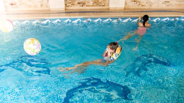 Porträtt av två leende tonårsflickor simma i poolen på gymmet — Stockfoto