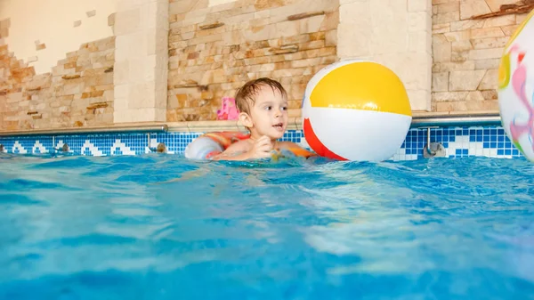 Evde kapalı yüzme havuzunda şişme plaj topu ve renkli halka ile oynayan mutlu neşeli yürümeye başlayan çocuk Portresi — Stok fotoğraf