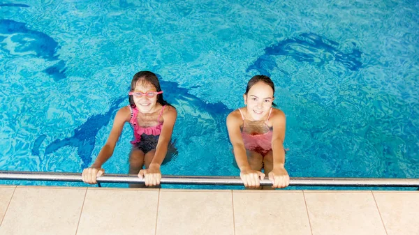 Portret van twee gelukkig glimlachende tiener meisjes in de indoor zwembad — Stockfoto