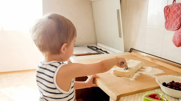 Primo piano ritratto di adorabile bambino di 3 anni bambino biscotti da forno e pasta rotolante con perno di legno. Piccolo chef cuoco — Foto Stock