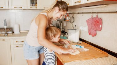 Sevimli 3 yaşındaki bebek çocuk annesi ile kurabiye pişirme Portresi. Aile pişirme ve pişirme