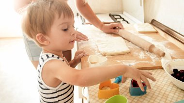 3 yaşındaki küçük oğlu ile anne portresi sabah mutfakta kurabiye pişirme. Evde aile pişirme ve pişirme