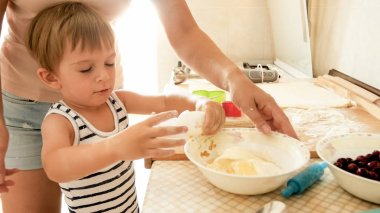 Sevimli 3 yaşındaki bebek çocuk annesi ile kurabiye pişirme Portresi. Aile pişirme ve pişirme