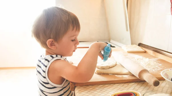Κοντινό πορτρέτο τριών ετών νήπιο αγόρι που στέκεται στην κουζίνα και μαγειρική ζύμη. Παιδικό ψήσιμο και πρωινό — Φωτογραφία Αρχείου
