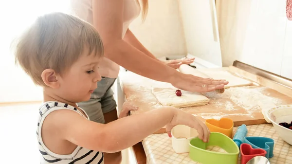 快乐微笑的幼儿与年轻的母亲在厨房烘烤和烹饪的肖像。家长在家教书育人 — 图库照片