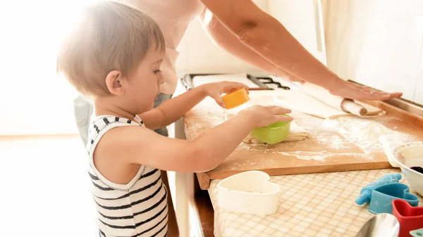 Portrait of cute 3 years old toddler boy cooking cookies with mother. Family cooking and baking — Stock Photo, Image