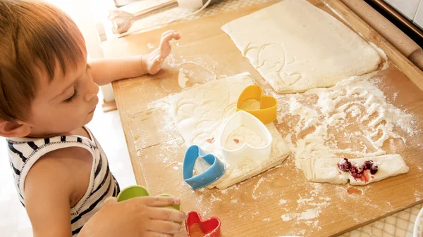 Primo piano ritratto di adorabile bambino di 3 anni bambino biscotti da forno e pasta rotolante con perno di legno. Piccolo chef cuoco — Foto Stock