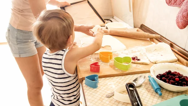 Πορτρέτο της μητέρας με 3 χρόνια νήπιο γιο ψήσιμο μπισκότα στην κουζίνα το πρωί. Οικογενειακό ψήσιμο και μαγείρεμα στο σπίτι — Φωτογραφία Αρχείου