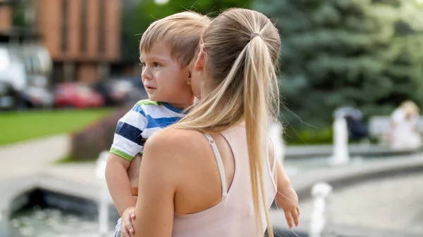 Close-up portret van jonge moeder knuffelen en strelen haar huilen weinig kind jongen in Park — Stockfoto