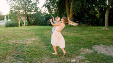 Onun küçük yürümeye başlayan çocuk ile tutarak ve dönen mutlu gülen anne Görüntü