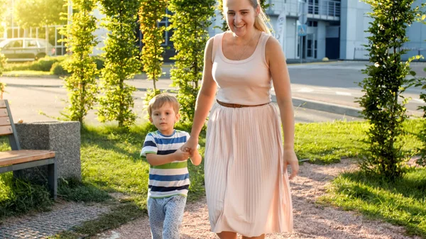 Foto de niño alegre feliz con madre joven caminando y corriendo en el parque —  Fotos de Stock