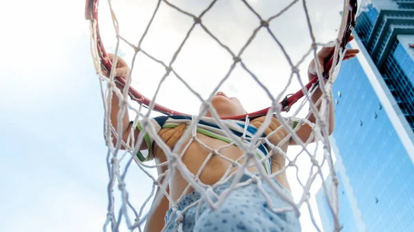 Closeup photo of active 3 years old toddler boy holding on basketball net ring. Concept of active and sporty children. Health of new generation kids — Stock Photo, Image