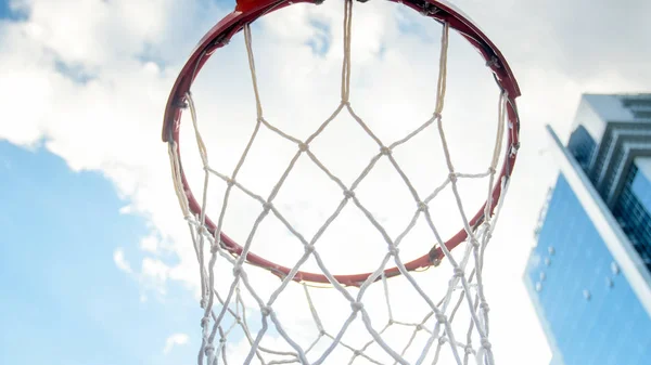 Closeup image of basketball ring with net on sports playground against blue sky with clouds — Stock Photo, Image