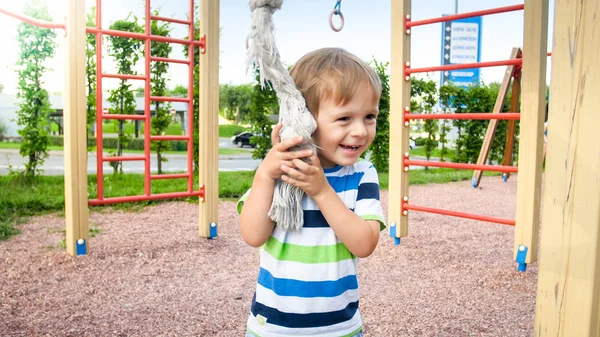 Närbild porträtt av bedårande leende lycklig liten pojke på barn lekplats på Park — Stockfoto