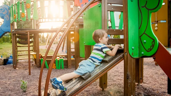 Porträtt av bedårande 3 år gammal pojke klättring på stege på barnen Palyground på Park — Stockfoto