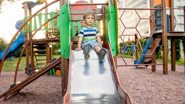 Imagem de feliz sorrindo criança alegre menino equitação e escalada no parque infantil grande crianças — Fotografia de Stock