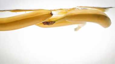 Taze olgun sarı muz düşen closeup fotoğraf düşen ve izole beyaz backgorund karşı berrak suda sıçrayan