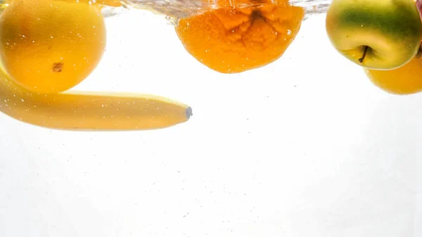 Крупним планом зображення багатьох смачних свіжих соковитих фруктів, що падають у воду і розбризкування — стокове фото