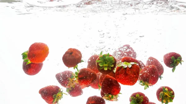 Nahaufnahme isoliertes Bild von vielen frischen reifen Himbeeren, die fallen und im Wasser planschen — Stockfoto