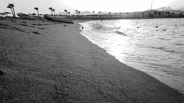 Beautiful black and white image of sandy sea beach on the sunset. Amazing landscape of shore and ocean waves — Stock Photo, Image