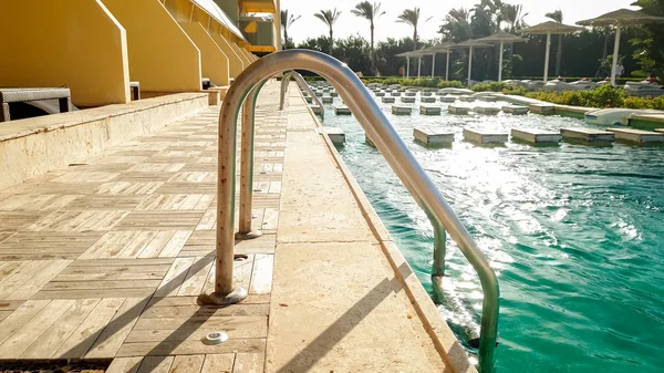Gros plan belle image des escaliers en métal dans la piscine à la villa luzurious au coucher du soleil — Photo