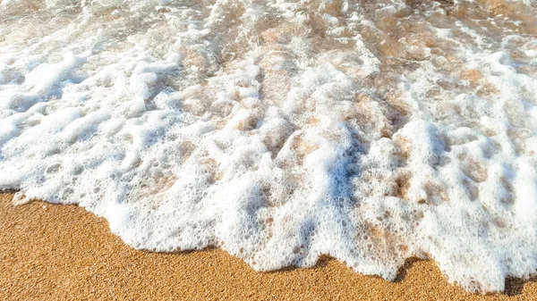 Foto de cerca de hermosas olas marinas rompiendo en la orilla. Arena húmeda y salpicaduras de agua en la playa —  Fotos de Stock
