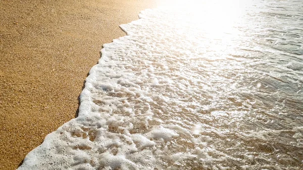 Foto de cerca de hermosas olas marinas rompiendo en la orilla. Arena húmeda y salpicaduras de agua en la playa —  Fotos de Stock