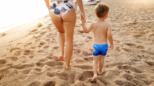 Belle image de sourire heureux 3 ans tout petit garçon marchant et se relaxant sur la plage de sable fin au coucher du soleil. Famille passer un bon moment pendant les vacances d'été à la plage — Photo