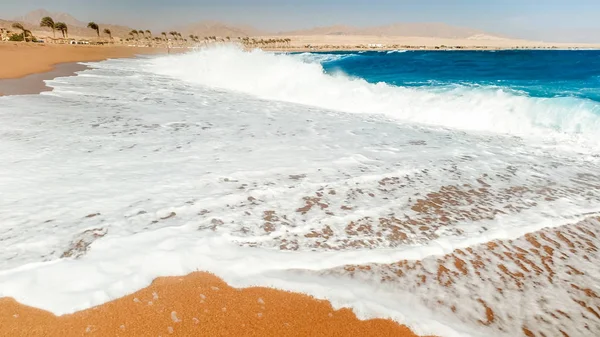 Na písku na pláži se potuloval obraz klidných nádherných mořských vln. Krajina oceánského pobřeží za slunečného dne — Stock fotografie