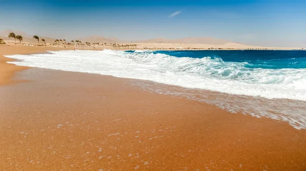 Zbliżenie zdjęcie pięknych fal morskich łamanie na brzegu. Mokry piasek i woda rozprysków na plaży — Zdjęcie stockowe