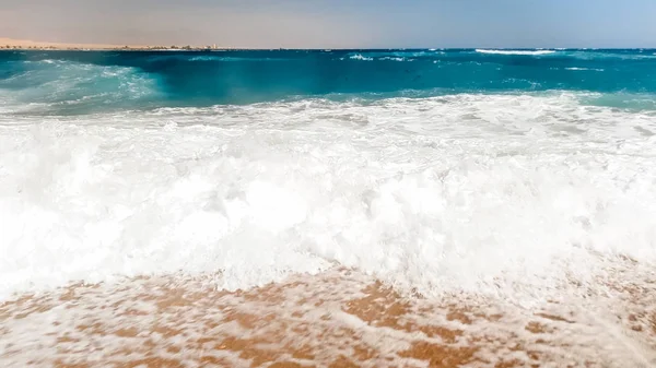 Photo rapprochée de belles vagues qui se brisent sur le rivage. Du sable humide et des éclaboussures d'eau sur la plage — Photo