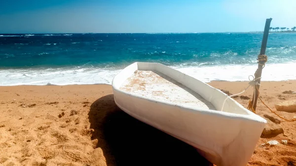 Piękny obraz starej drewnianej łodzi rybaka leżącego na piaszczystej plaży w jasnym, słonecznym dniu — Zdjęcie stockowe