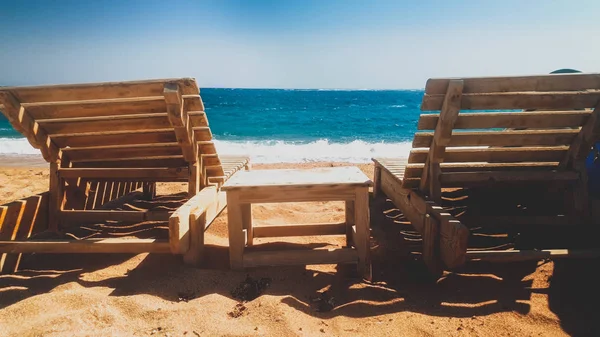 Hermosa foto tonificada de playa de mar abandonada con viejas tumbonas de madera o tumbonas en la orilla en un día soleado y ventoso. Concepto de crisis en los viajes o el turismo —  Fotos de Stock