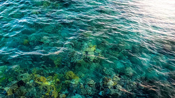 Zdjęcie pięknej turkusowej wody morskiej i skał leżących na dole — Zdjęcie stockowe